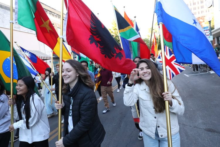 Students carrying different cultural flags in Baylor's Homecoming Parade.